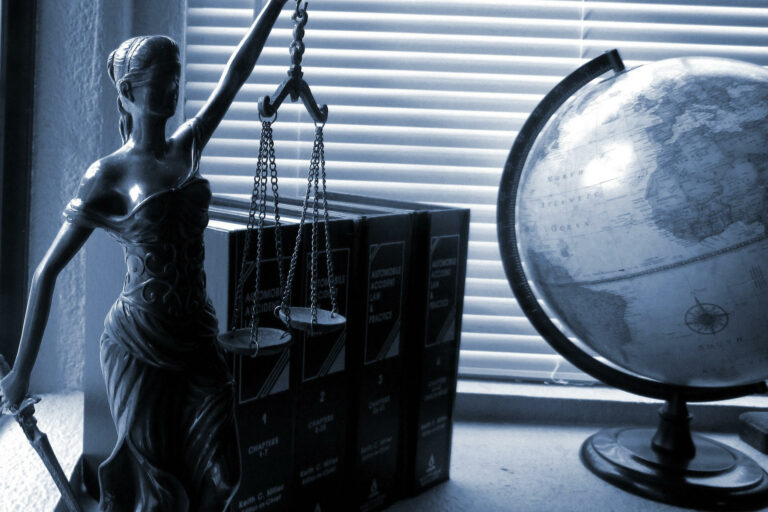 A picture of a statue of Lady Justice and an earth globe.