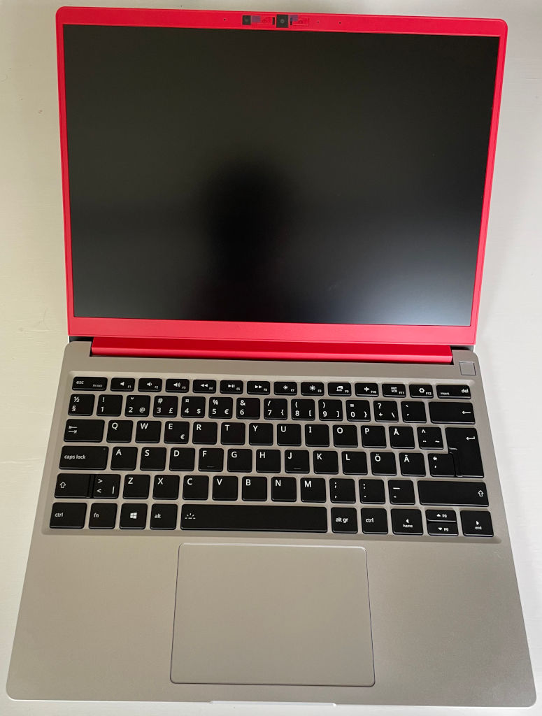 Picture of the the laptop completely assembled. The red bezel stands out in the picture and makes the computer unique.